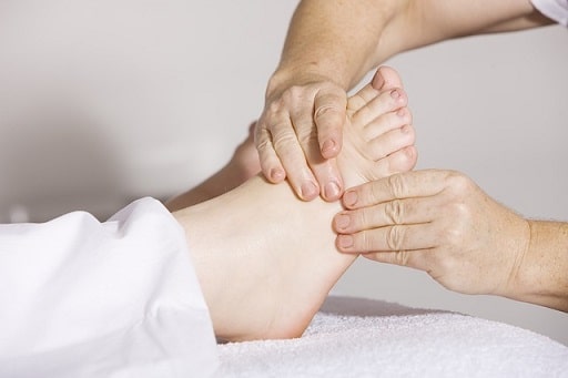 Frau bekommt eine Fußreflexzonen Massage